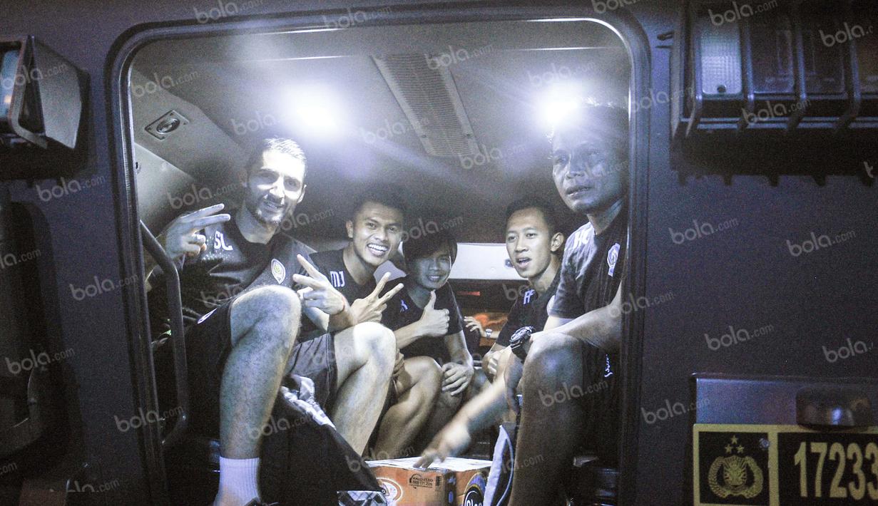 Pemain Arema Cronus, Srdan Lopicic dan rekan-rekannya naik mobil rantis (kendaraan taktis) Polri usai bertanding melawan Madura United di Stadion Gelora Bangkalan, Jumat (6/5/2016). (Bola.com/Iwan Setiawan)