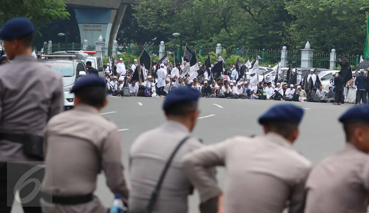 Massa aksi damai 4 November bersiap menggelar salat Jumat di Jalan Merdeka Barat, Jakarta, Jumat (4/11). Personel keamanan dari kepolisian pun disiagakan berbaris berhadapan dengan massa pendemo. (Liputan6.com/Faizal Fanani)