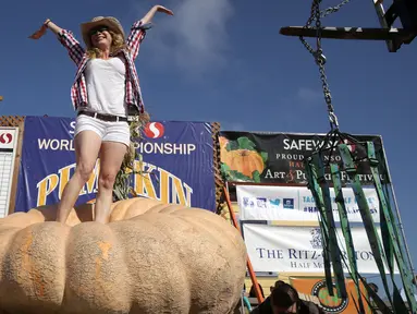 Cindy Tobeck berdiri di atas labu seberat 1.736 pon miliknya dalam lomba Safeway World Championship Pumpkin Weigh-Off di Half Moon Bay, California, Amerika Serikat, Senin (14/10/2019). Seorang petani keluar sebagai juara dengan labu seberat 2.175 pon miliknya. (Justin Sullivan/Getty Images/AFP)