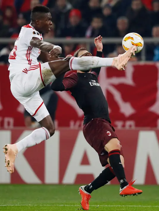 Pemain Olympiakos Piraeus, Pape Abou Ciss berebut bola dengan pemain AC Milan, Gonzalo Higuain dalam laga keenam Grup F Liga Europa di Stadion Georgios Karaiskakis, Kamis (13/12). AC Milan kandas di Liga Europa setelah kalah 1-3. (AP/Petros Giannakouris)