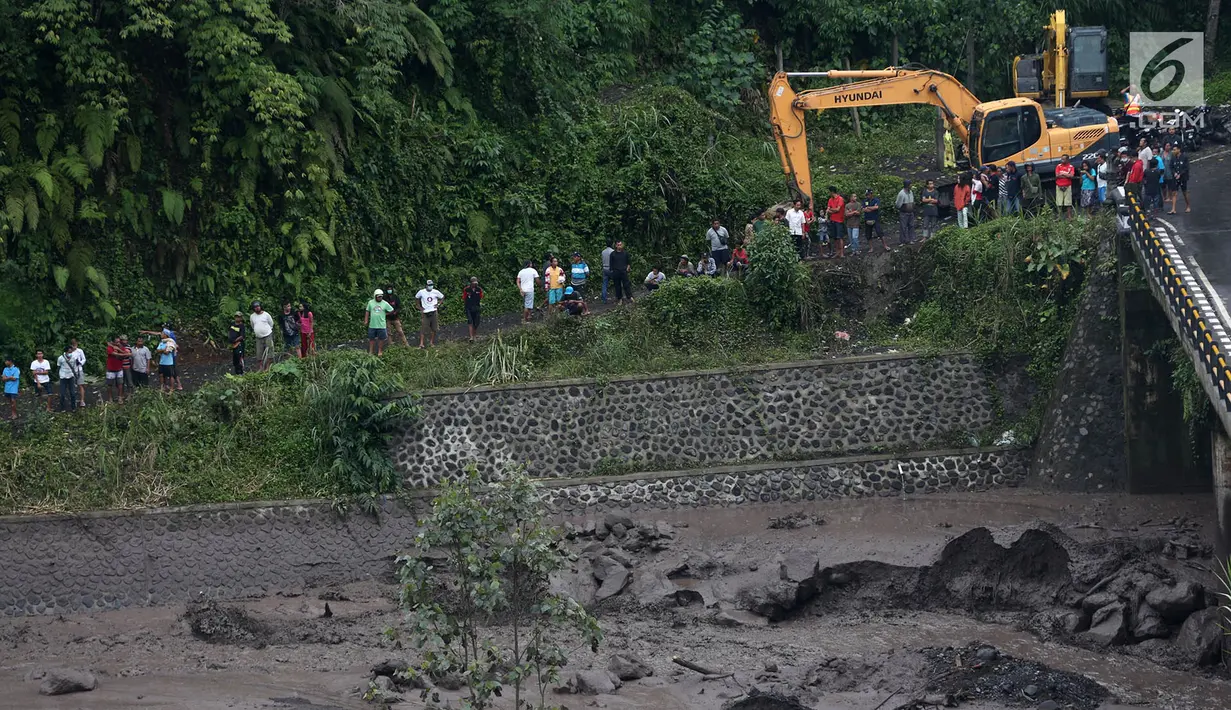 Warga beramai-ramai menyaksikan aliran lahar dingin yang melintasi Sungai Yeh Sah di Karangasem, Bali, Sabtu (2/12). (Liputan6.com/Immanuel Antonius)