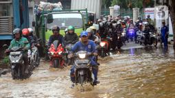 Imbas hujan besar yang mengguyur Jakarta semalam, terjadi genangan air di depan Pasar Induk Kramat Jati, Jakarta Timur. (merdeka.com/Arie Basuki)