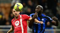 Romelu Lukaku berduel dengan pemain Monza. Inter Milan kalah 0-1 pada pertandingan lanjutan Liga Italia 2022/2023 hari Minggu (16/04/2023) dini hari WIB. (GABRIEL BOUYS / AFP)