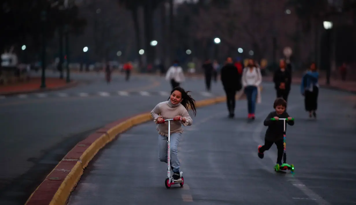 Anak-anak bermain skuter saat pembukaan kembali area Buenos Aires di Argentina, Senin (20/7/2020). Tempat-tempat yang biasa dikunjungi warga mulai dibuka setelah pemerintah Argentina mulai melonggarkan pemberlakuan pembatasan untuk pencegahan penyebaran corona COVID-19. (AP Photo/Natacha Pisarenko)