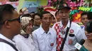 Seorang pria berwajah mirip Presiden Joko Widodo (Jokowi) berswafoto bersama warga yang memadati sekitar Gedung Graha Saba Buana, Solo, Rabu (8/11). Pria bernama David itu beberapa saat berhasil mengecoh warga. (Liputan6.com/Angga Yuniar)