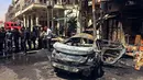 Pasukan keamanan Irak dan warga sipil memeriksa lokasi serangan bom di Baghdad, Irak (30/5). Serangan bom ini sedikitnya telah menewaskan 13 orang dan melukai 24 lainnya. (AP Photo / Karim Kadim)