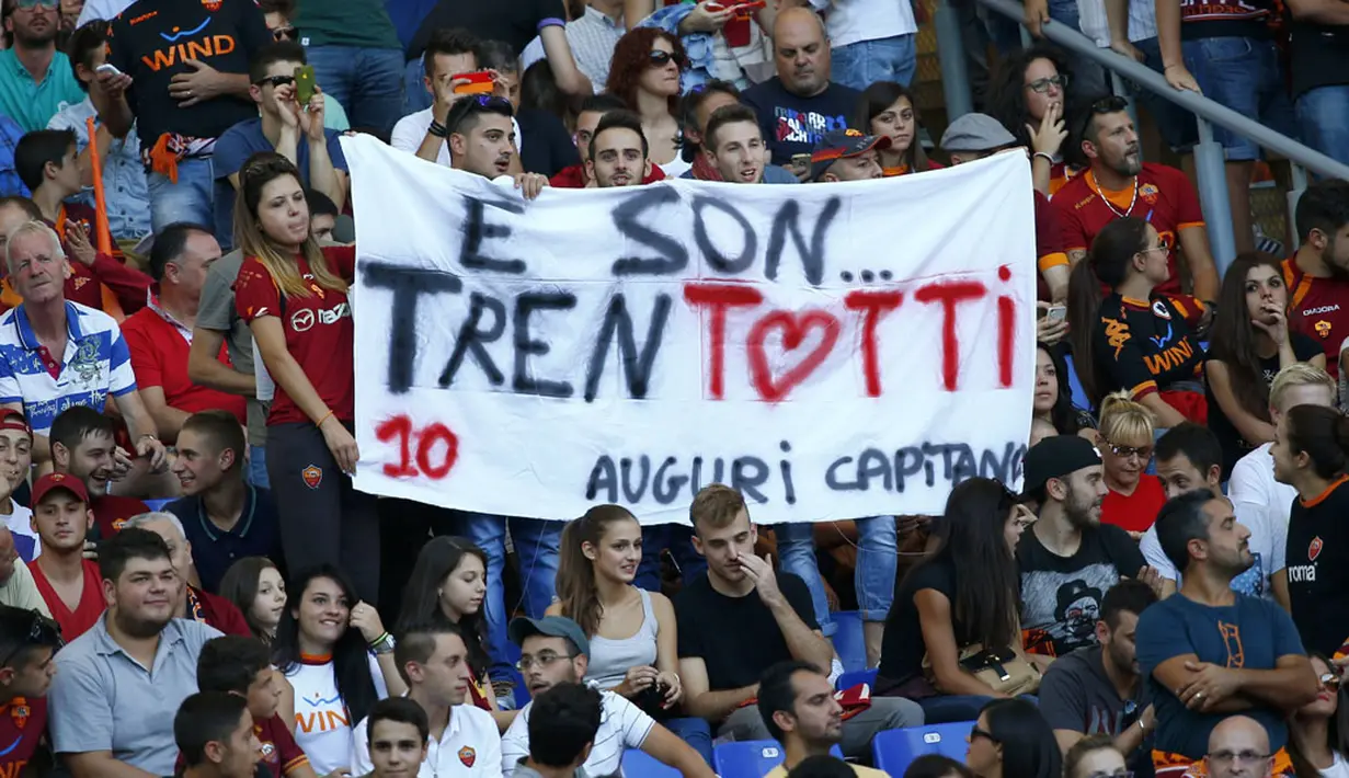 Suporter AS Roma membentangkan spanduk bertuliskan ucapan selamat ulang tahun kepada Francesco Totti saat menyaksikan laga AS Roma kontra Hellas Verona di Stadion Olimpiade, Roma (27/9/2014). (REUTERS/Tony Gentile)