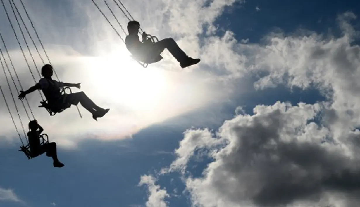 Pengunjung menaiki Chairoplane di lapangan Theresienwiese saat Festival Bir Oktoberfest di Munich, Jerman (19/9/2015). Oktoberfest di Jerman adalah festival bir terbesar di dunia yang akan berlangsung hingga 4 Oktober 2015. (AFP Photo / Christof stache) 
