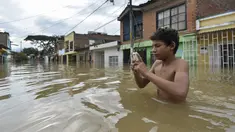 Banjir melanda kawasan Cali di Kolombia, Selasa (16/5). Banjir terjadi setelah hujan lebat dan menyebabkan meluapnya sungai Cauca. (AFP PHOTO / LUIS ROBAYO)