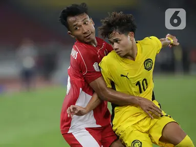 Pemain Timnas Indonesia U-23, Robi Darwis (kiri) berebut bola dengan Mohammad Haykal Danish Bin Mohd Haizon (Malaysia) pada laga lanjutan Grup A Piala AFF U-23 2025 di Stadion Utama Gelora Bung Karno, Jakarta, Senin (21/7/2025). (Liputan6.com/Helmi Fithriansyah)