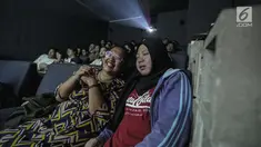 Sejumlah penyandang tunanetra mendengarkan relawan bisik saat menyaksikan film di Bioskop Bisik di Pavilliun 28, Jakarta, Minggu (14/1).  Kini, menonton bioskop bukan menjadi hal mustahil lagi bagi penyandang tunanetra. (Liputan6.com/Faizal Fanani)