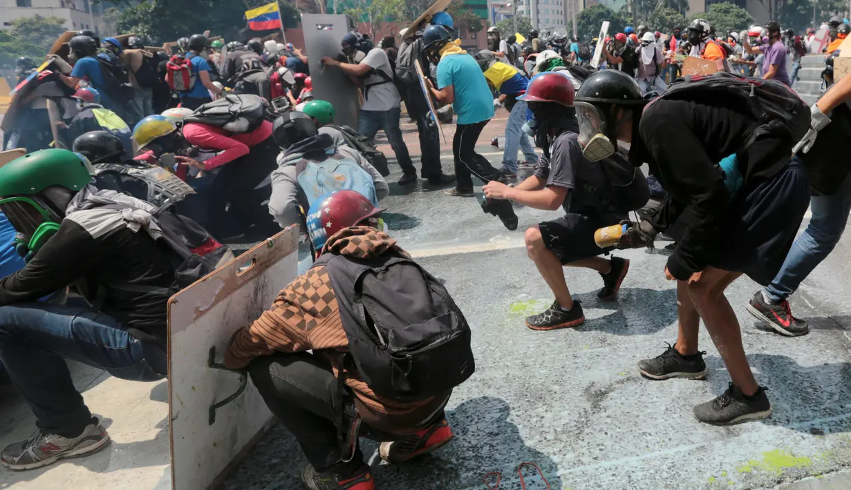 Demonstran anti-Presiden Venezeula Nicholas Maduro memegang botol tinja saat unjuk rasa di Caracas, 10 Mei 2017. Pengunjuk rasa kini menggunakan bom 'poopootov' untuk menyerang petugas yang menghalangi jalannya demo. (AP Photo/Fernando Llano)