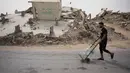 UNICEF mencatat 90 persen penduduk Gaza tidak memiliki akses aman terhadap air minum, sementara 96 persen air tanah telah tercemar dan tidak layak digunakan. Tampak dalam foto, seorang pria Palestina membawa wadah air di Kota Gaza, Selasa 12 Mei 2026. (AP Photo/Abdel Kareem Hana)