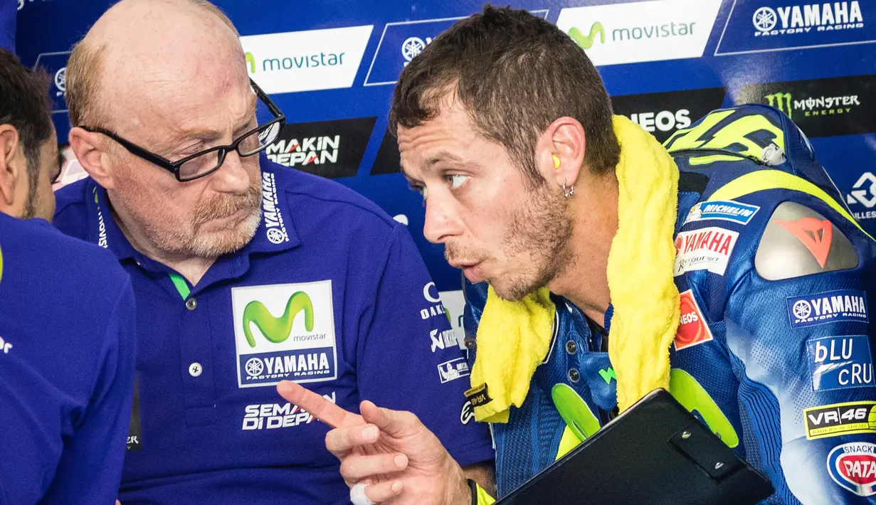 Valentino Rossi berdiskusi dengan tim mekaniknya saat hari kedua tes pramusim di Sirkuit Sepang, Malaysia, Selasa (31/1). Valentino mengaku puas dengan performa YZR-M1 yang ditungganginya saat ini. (AP PHOTO)