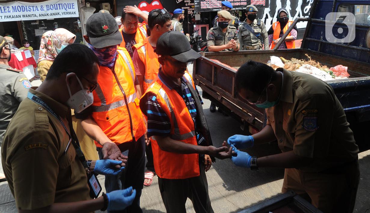 Pelanggar PSBB menjalani rapid test saat razia masker di Pasar Reni, Pamulang, Tangerang Selatan, Banten, Selasa (1/9/2020). Rapid test dilakukan guna mencegah penularan COVID-19. (merdeka.com/Arie Basuki)
