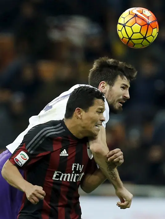 Penyerang AC Milan, Carlos Bacca (depan) berebut bola udara dengan bek Fiorentina, Nenad Tomovic pada lanjutan Serie A Liga Italia di Stadion San Siro (17/1). AC Milan menang atas Fiorentina dengan skor 2-0. (REUTERS/Alessandro Garofalo)