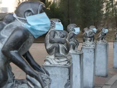 Sejumlah patung monyet yang berada di Kebun Binatang Beijing terlihat dipakaikan masker sebagai bentuk protes di China, 19 Desember 2016. China dilanda oleh asap polusi yang paling buruk tahun 2016 selama beberapa hari ini. (AFP PHOTO/STR/China OUT)