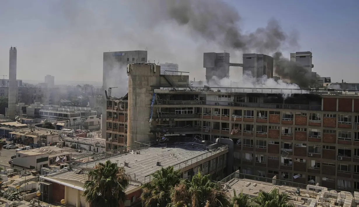 Asap mengepul dari bangunan kompleks rumah sakit Soroka setelah dihantam rudal yang ditembakkan dari Iran di Be'er Sheva, Israel, Kamis, 19 Juni 2025. (AP Photo/Leo Correa)