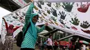 Warga memegang spanduk sepanjang satu kilometer bekas Cap tangan anak-anak Indonesia, di Kawasan Car Free Day, Bundaran HI, Jakarta (24/9). Spanduk tersebut untuk menunjukkan dukungan kepada Etnis minoritas Rohingya di Myanmar. (Liputan6.com/Johan Tallo)
