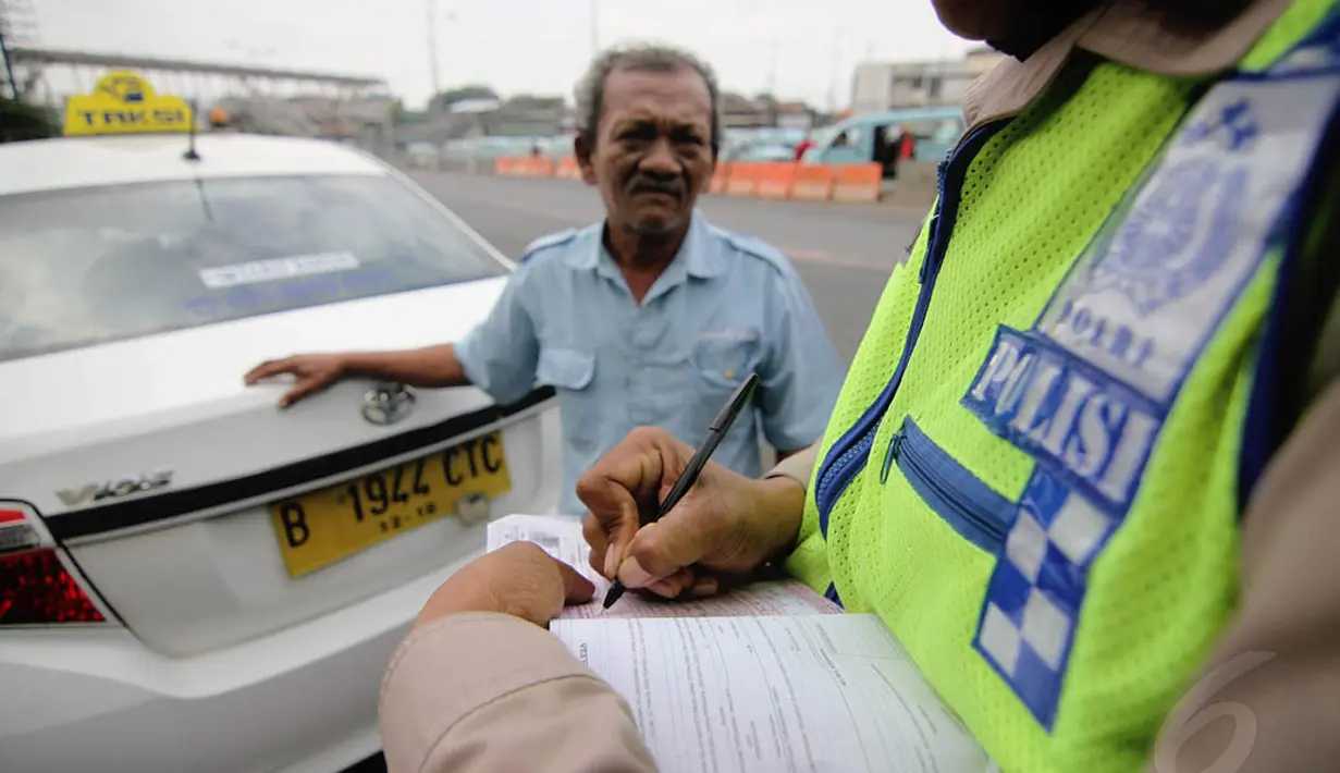 Petugas kepolisian melakukan tilang pada sopir taksi saat operasi zebra di kawasan Kampung Melayu, Jakarta, Jumat (5/12/2014). (Liputan6.com/Faizal Fanani)