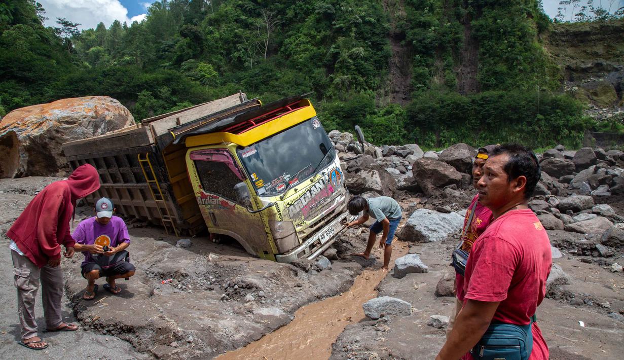Peristiwa yang terjadi pada Selasa (3/3/2026) sore sekitar pukul 15.30 WIB menewaskan tiga orang. Tampak dalam foto, warga berusaha mengambil bagian-bagian truk yang terkubur di pasir setelah longsor lumpur akibat hujan dari Gunung Merapi di Sungai Senowo, Magelang, Jawa Tengah pada Rabu 4 Maret 2026. (Devi Rahman/AFP)