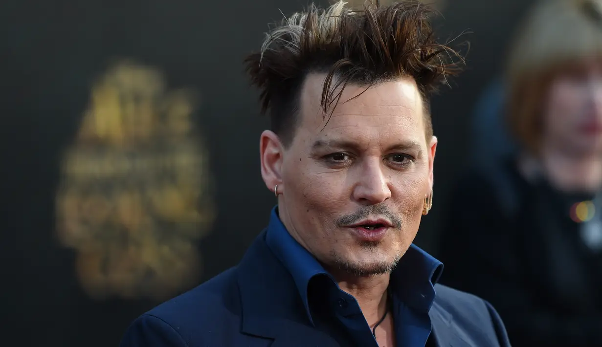 Gaya rambut berantakan Johnny Depp ketika menghadiri premiere film 'Alice Through The Looking Glass' di Hollywood, California, 23 Mei 2016. Aktor 52 tahun itu tampil dengan setelan biru dongker. (Robyn BECK / AFP)