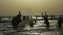 Para pemuda bermain air saat mendinginkan tubuhnya di laut selama musim panas di Karachi, Pakistan (14/6/2019). Memasuki musim panas, warga Pakistan ramai-ramai mendinginkan tubuhnya di laut. (AFP Photo/Asif Hassan)