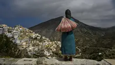 Foto yang diambil pada 6 Mei 2023 ini menunjukkan patung yang didedikasikan untuk perempuan Olympos, menghadap ke desa terpencil di pulau Karpathos. Di utara pulau Karpathos Yunani, desa lereng bukit Olympos adalah rumah bagi salah satu dari sedikit masyarakat matriarkal di Yunani yang menolak standardisasi pariwisata dan gaya hidup. (Louisa GOULIAMAKI / AFP)