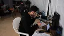 Upaya ini merupakan langkah darurat untuk memastikan hak pendidikan anak-anak tetap terpenuhi di tengah krisis keamanan dan kemanusiaan yang sedang berlangsung di Lebanon. Tampak dalam foto, seorang pria Lebanon yang mengungsi melanjutkan studinya secara daring di sebuah sekolah negeri yang diubah menjadi tempat penampungan, di kota Dekwaneh, utara Beirut pada Rabu 25 Maret 2026. (Anwar AMRO/AFP)