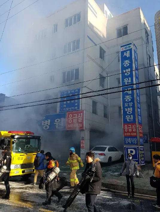 Kepulan asap terlihat saat petugas pemadam kebakaran berusaha memadamkan api yang membakar rumah sakit Sejong di Milyang, Korea Selatan,  Jumat (26/1). Bangunan lima lantai itu merupakan rumah sakit dan juga panti jompo. (Kim Dong-mi/Yonhap via AP)
