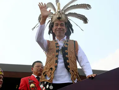 Presiden Joko Widodo melambaikan tangan ke warga dalam Festival Karnaval Khatulistiwa, Pontianak, Sabtu (22/8/2015).Pontianak menjadi tuan pertama Festival Karnaval Khatulistiwa yang diselenggarakan di luar Jakarta. (Liputan6.com/Faizal Fanani)