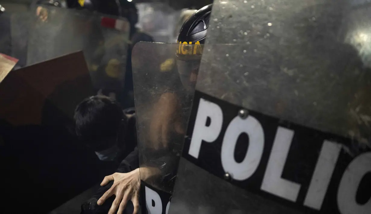 Seorang demonstran bentrok dengan polisi anti huru-hara selama demonstrasi anti pemerintah di Lima, Peru pada 21 September 2025. (ERNESTO BENAVIDES/AFP)
