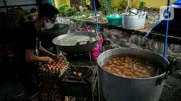 Petugas Taruna Siaga Bencana (Tagana) merebus telur di Dapur Umum Kementerian Sosial di GOR Otista, Jakarta, Minggu (21/2/2021). Dalam sehari, petugas menyiapkan hingga 6.000 paket nasi kotak yang didistribusikan ke 11 kelurahan terdampak banjir. (Liputan6.com/Faizal Fanani)