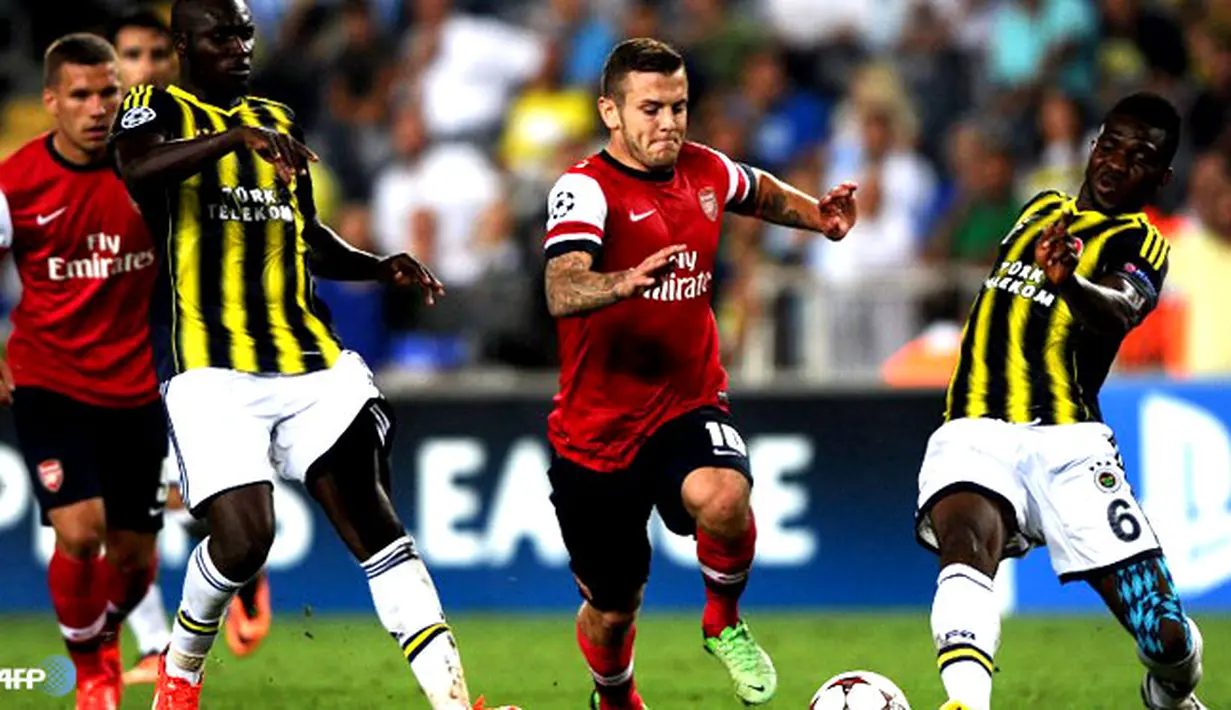 Duel perebutan bola antara Jack Wilshere dengan Joseph Yobo pada pertandingan Play-off Liga Champions antara Fenerbahce melawan Arsenal di Stadion Sukru Saracoglu di Istanbul pada 21 Agustus 2013. (AFP/Bulent Kilic)