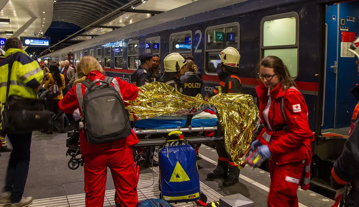 Seorang penumpang kereta yang terluka akibat dua gerbong kereta bertabrakan menerima perawatan dari tim medis di stasiun kereta api utama di Salzburg, Austria (20/4). (FMT/Wolfgang Moser/APA/AFP)