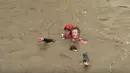 Petugas penyelamat mengevakuasi seorang pria dari Sungai Salinas yang berlumpur saat terjadi banjir bandang di Paso Robles, California (22/3). Banjir bandang ini disebabkan karena Badai Pasifik yang melanda California. (KSBY-TV melalui AP)
