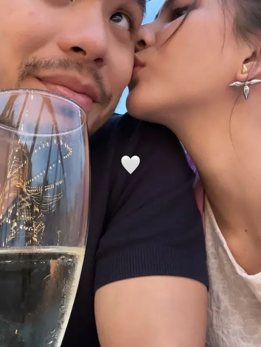 Mencium mesra sang suami, Jessica menambah penampilannya dengan anting-anting silver berbentuk bintang yang menarik.  (@jscmila)