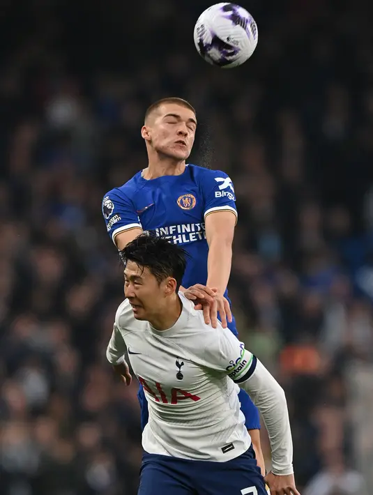 Bek Chelsea #42 Alfie Gilchrist memenangkan sundulan dari striker Tottenham Hotspur #07 Son Heung-Min pada laga tunda pekan ke-26 Premier League 2023/2024 di Stamford Bridge, Jumat (3/5/2024) dini hari WIB. (Glyn KIRK / AFP)