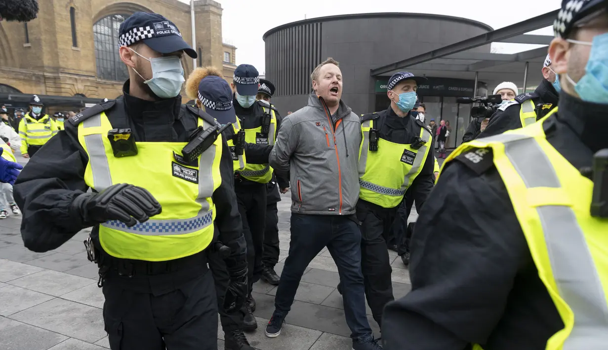 Seorang demonstran diamankan oleh para petugas polisi dalam aksi protes anti-lockdown di London, Inggris,  28 November 2020. Lebih dari 60 orang ditangkap saat bentrokan antara sejumlah demonstran anti-lockdown dan polisi terjadi di pusat kota London pada Sabtu (28/11). (Xinhua/Ray Tang)