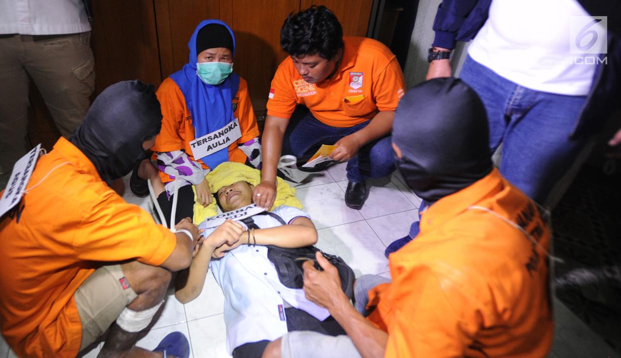 Tersangka Aulia Kesuma (dua kiri) saat rekonstruksi pembunuhan suami dan anak tirinya di Jalan Lebak Bulus 1, Cilandak, Jakarta Selatan, Kamis (5/9/2019). Aulia menghabisi nyawa Edi Chandra Purnama alias Pupung Sadili dan anaknya M. Adi Pradana alias Dana di rumah ini. (merdeka.com/Arie Basuki)