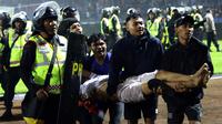 Suporter membawa seorang pria yang terluka menyusul kerusuhan pada pertandingan sepak bola antara Arema Vs Persebaya di Stadion Kanjuruhan, Malang, Jawa Timur, 1 Oktober 2022. "Masih ada 180 orang yang masih dalam perawatan. Dari 40 ribu penonton, tidak semua anarkis. Hanya sebagian, sekitar 3.000 penonton turun ke lapangan," kata Kapolda Jawa Timur Irjen Pol Nico Afinta. Hingga kini, data korban meninggal dunia masih terus bertambah. (AP Photo/Yudha Prabowo)