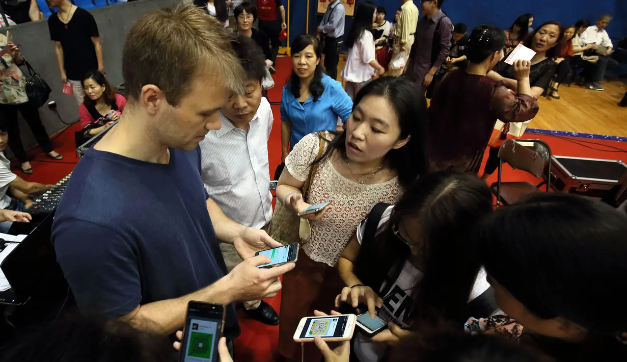 Seorang peserta asing menambahkan teman ke sebuah aplikasi smartphone saat mengikuti acara perjodohan di Hangzhou, China, Minggu (29/5/2016). Acara yang diselenggarakan di Universitas Zhejiang ini menarik minat lebih dari 20.000 orang lajang. (STR/AFP)