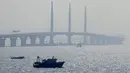 Sebuah perahu berlayar dekat jembatan Hong Kong-Zhuhai-Macau di kota Zhuhai, China selatan, Rabu (28/3). Jembatan laut terpanjang di dunia itu menghubungkan Hong Kong, Macau, dan Zhuhai—tiga kota terpenting dan makmur di China. (AP Photo/Kin Cheung)