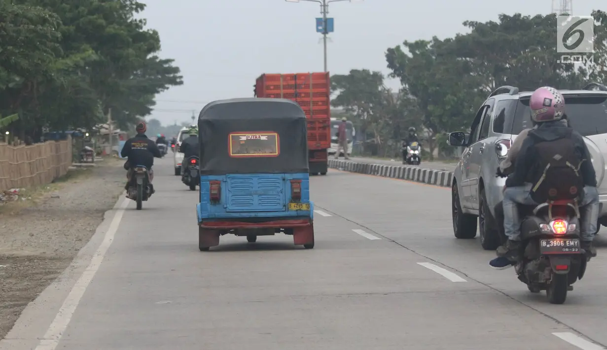 Pemudik bersama keluarganya menggunakan bajaj saat perjalanan mudik melintasi Jalur Pantura kawasan Patrol, Jawa Barat, Senin (3/6/2019). Keluarga ini memanfaatkan bajajnya sebagai angkutan mudik dari Jakarta menuju kampung halamannya di Cirebon, Jawa Tengah. (Liputan6.com/Herman Zakharia)