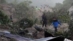 Polisi dan penduduk setempat menyisir lokasi tanah longsor saat mencari korban di Santa Catarina Pinula, Guatemala (2/10/2015). Penyelamatan dan pencarian personil terus bekerja di daerah sampai saat ini. (REUTERS/Josue Decavele)