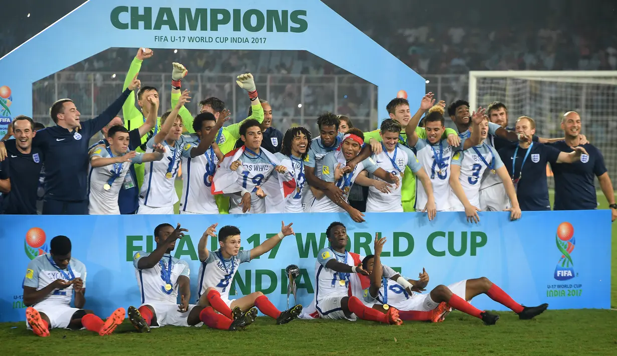 Selebrasi para pemain Timnas Inggris dengan medali dan trofi juara Piala Dunia U-17 2017 setelah mengalahkan Spanyol pada laga final di Vivekananda Yuba Bharati Krirangan Stadium, India (28/10/2017). Inggris juga tercatat baru satu kali meraih trofi juara Piala Dunia U-17, yaitu pada 2017 di India dengan mengalahkan Spanyol 5-2 di partai final. (AFP/Dibyangshu Sarkar)