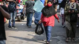 Warga membawa barang belanjaan dengan menggunakan kantong plastik di Kawasan Pasar Jatinegara, Jakarta, Selasa (30/6/2020). Pemerintah Provinsi DKI Jakarta bakal resmi menerapkan larangan penggunaan kantong plastik sekali pakai mulai Rabu, 1 Juli 2020 besok. (Liputan6.com/Faizal Fanani)