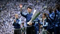 Penyerang Tottenham Hotspur asal Korea Selatan #07, Son Heung-Min, membawa trofi Liga Europa, setelah kemenangan mereka di Final Liga Europa pada pertengahan pekan lalu, 21 Mei. Ia dan tim memamerkan trofi tersebut kepada para penggemar setelah pertandingan Premier League&nbsp;antara Tottenham Hotspur dan Brighton and Hove Albion di Stadion Tottenham Hotspur, London, pada 25 Mei 2025. (JUSTIN TALLIS /AFP)