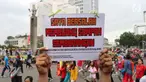 Seorang warga menunjukkan tulisan Saya Bersalah Membuang Sampah Sembarangan saat CFD di Jakarta, Minggu (28/1). Petugas Dari Suku Dinas Lingkungan Hidup DKI Jakarta melakukan OTT bagi para warga yang kedapatan membuang sampah. (Liputan6.com/Angga Yuniar)