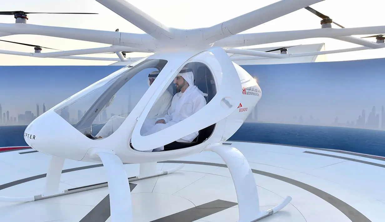 Putra Mahkota Shaikh Hamdan Bin Mohammed bin Rashid Al Maktoum menjajal drone yang akan dioperasikan sebagai taksi terbang dalam uji coba di Dubai, UEA, Senin (25/9). Mobil terbang Volocopter ini mampu beroperasi tanpa pilot atau awak. (Handout/WAM/AFP)
